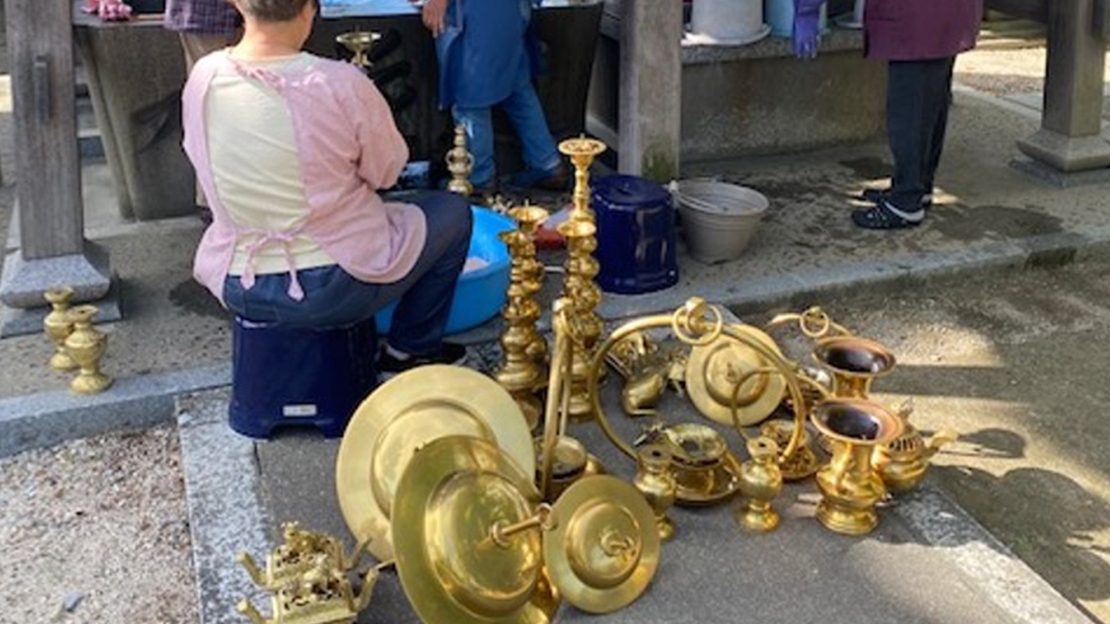 仏具を磨く女性たちと磨かれた仏具